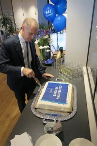 SAS koncernchef Rickard Gustafson skär upp jubileumstårtan.