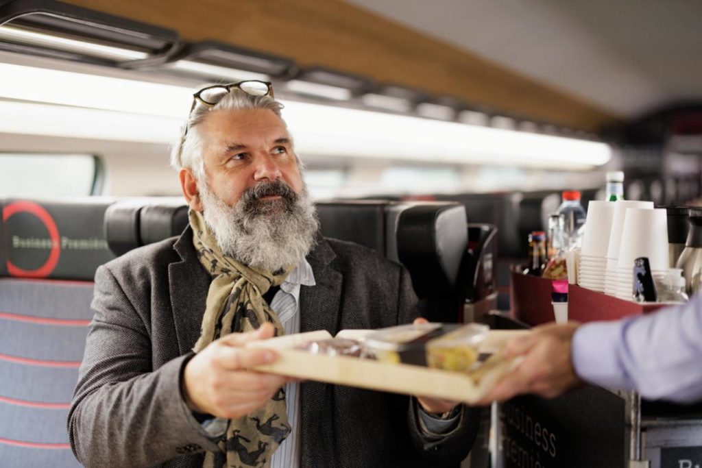 man som blir erbjuden en måltid under en sncf business premiere class tågsträcka